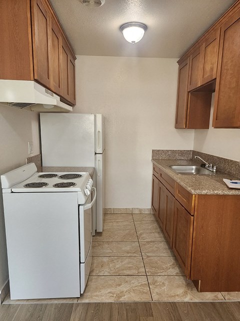 a kitchen with a stove refrigerator and sink